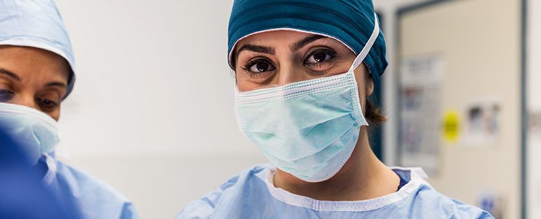 Female doctor with surgical mask on face.