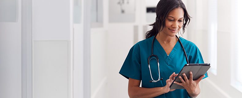 Doctor using electronic health record (EHR) app on tablet.