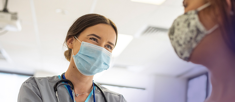 Nurse smiling at patient and taking vitals